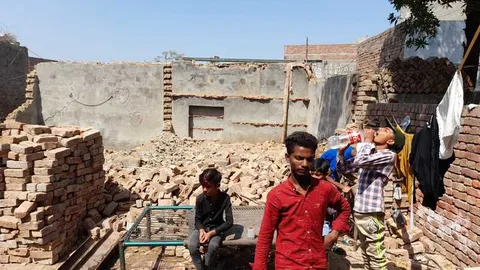 Two men at a construction site with unfinished walls and stacks of bricks