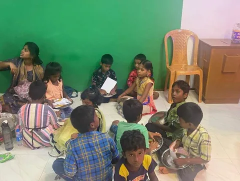 Children seated in a circle with an adult holding an open book