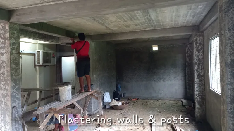 Worker plastering an interior wall