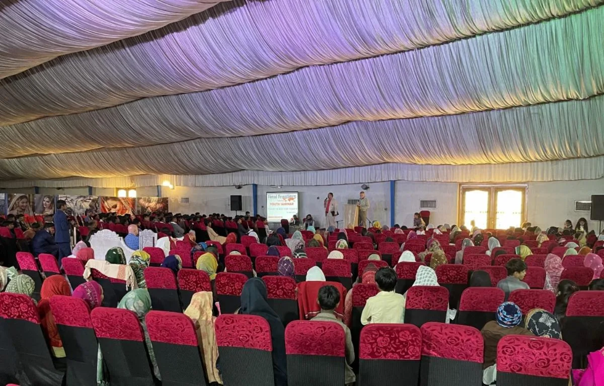 Audience seated in a large tent at a Pakistan youth seminar