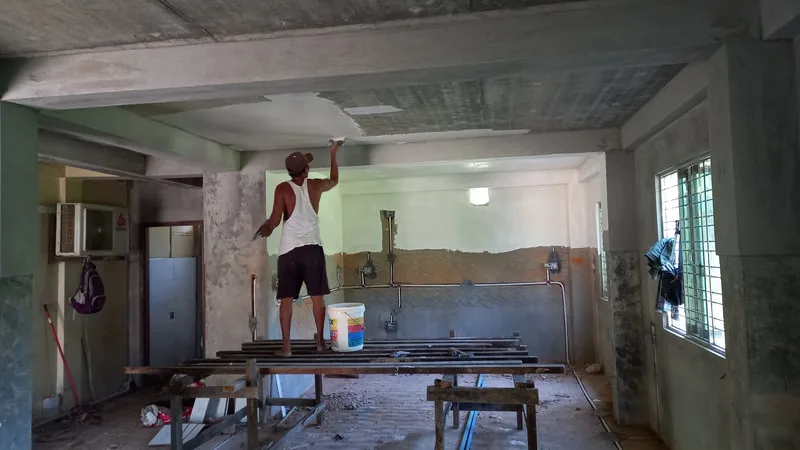 Workers painting an interior ceiling