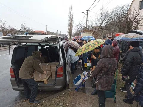 People gathered around supply vehicles