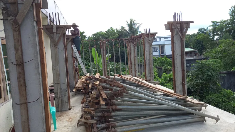 Scaffolding stacked beside unfinished concrete columns