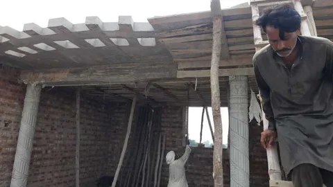 Workers beneath an unfinished concrete ceiling