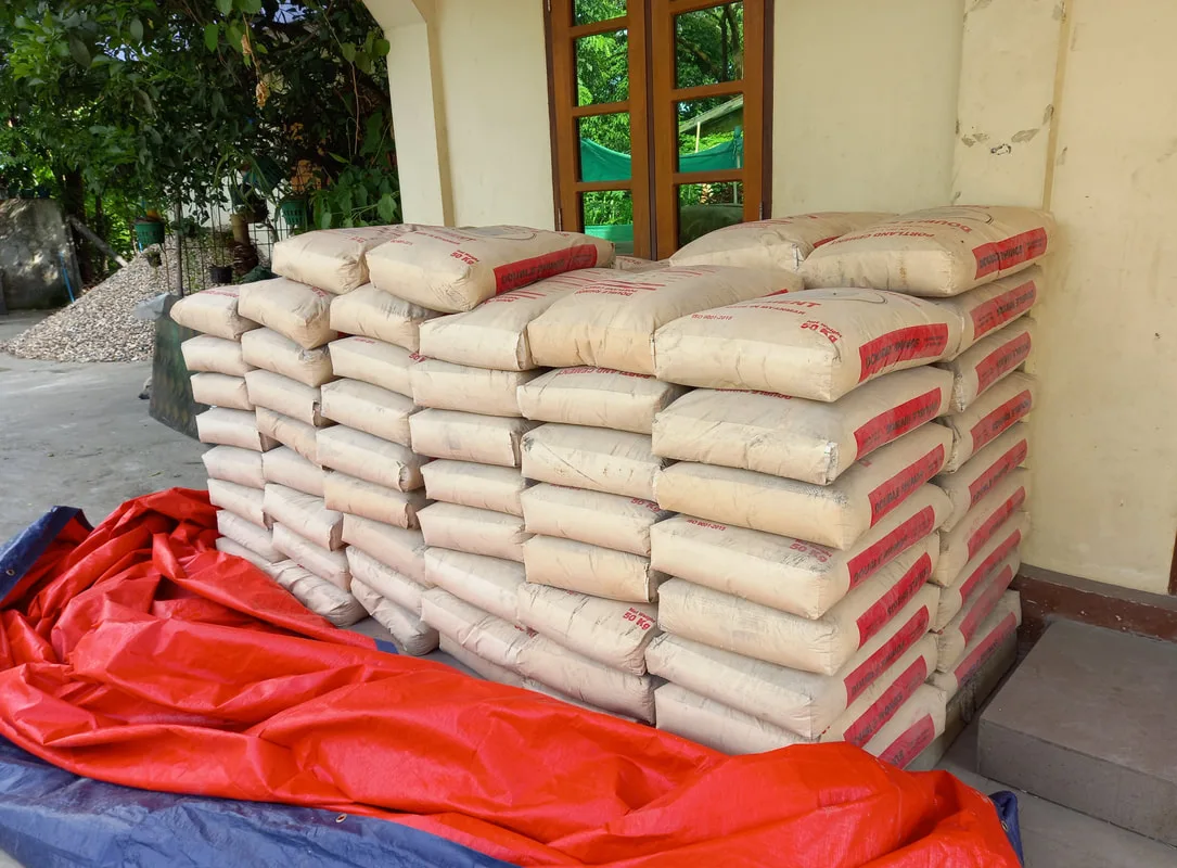 Stacked cement bags on a red sheet