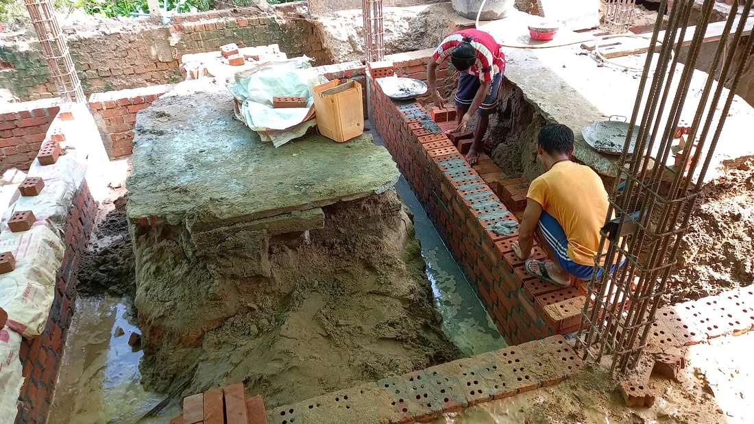Workers laying foundation brickwork