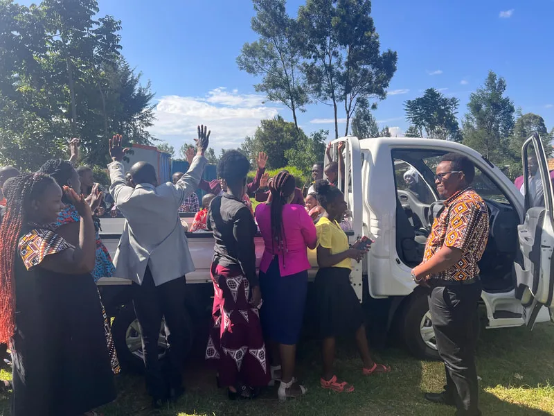 Group celebrating beside a delivery truck