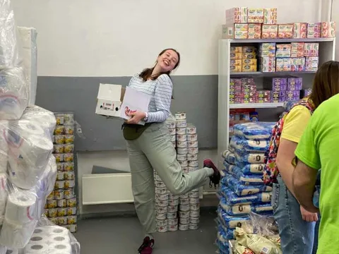 Woman holding a box in a food storeroom