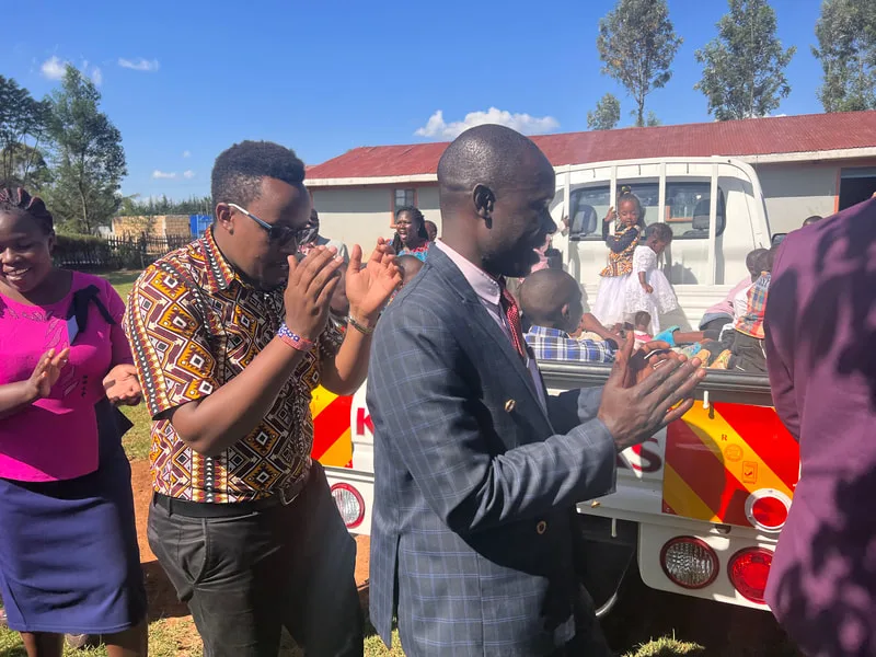 People applauding beside a delivery truck