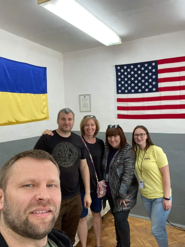 Volunteers standing beneath Ukrainian and American flags