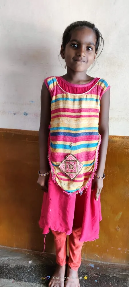 Child standing against an indoor wall