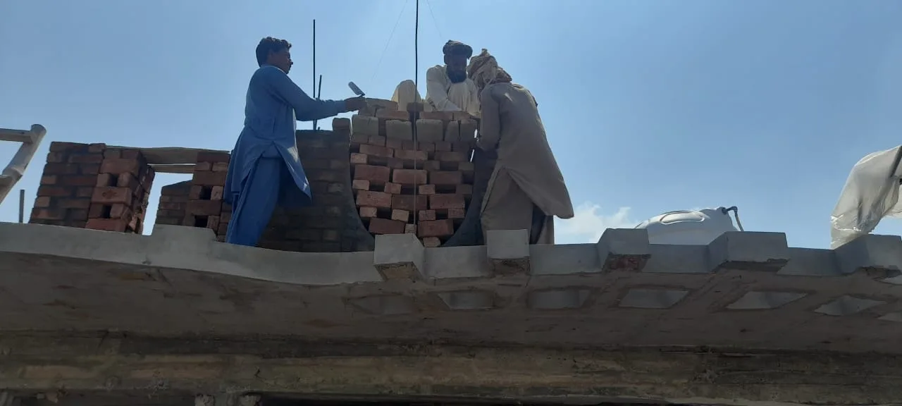 Workers raising a decorative brick arch
