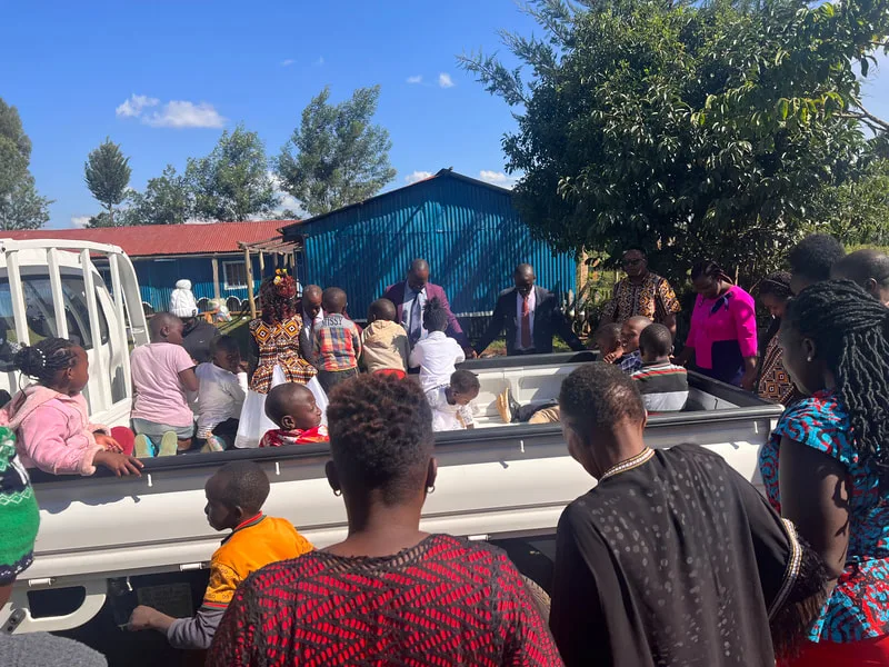 People seated in the bed of a delivery truck