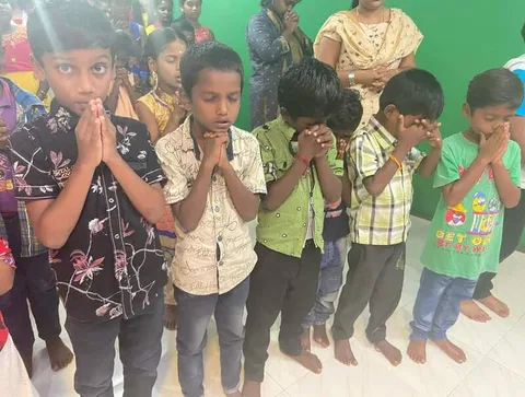 Children standing with hands clasped together