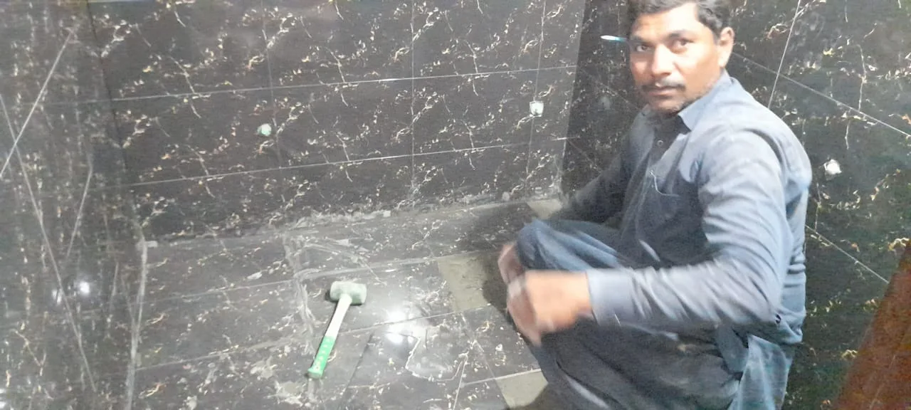 Worker beside a tiled wall