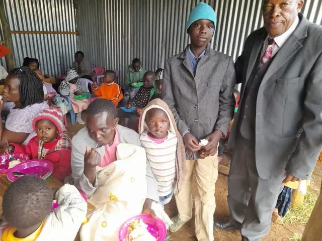 Adults and children inside a feeding center