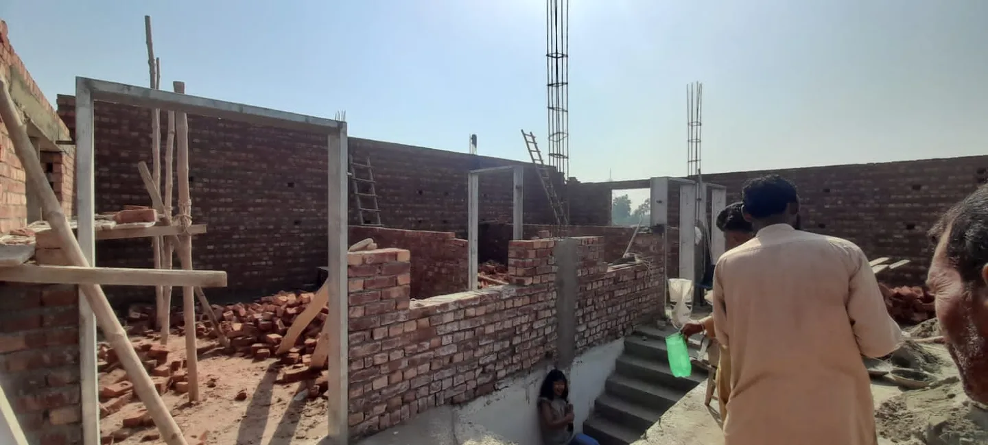 Worker walking between unfinished brick walls
