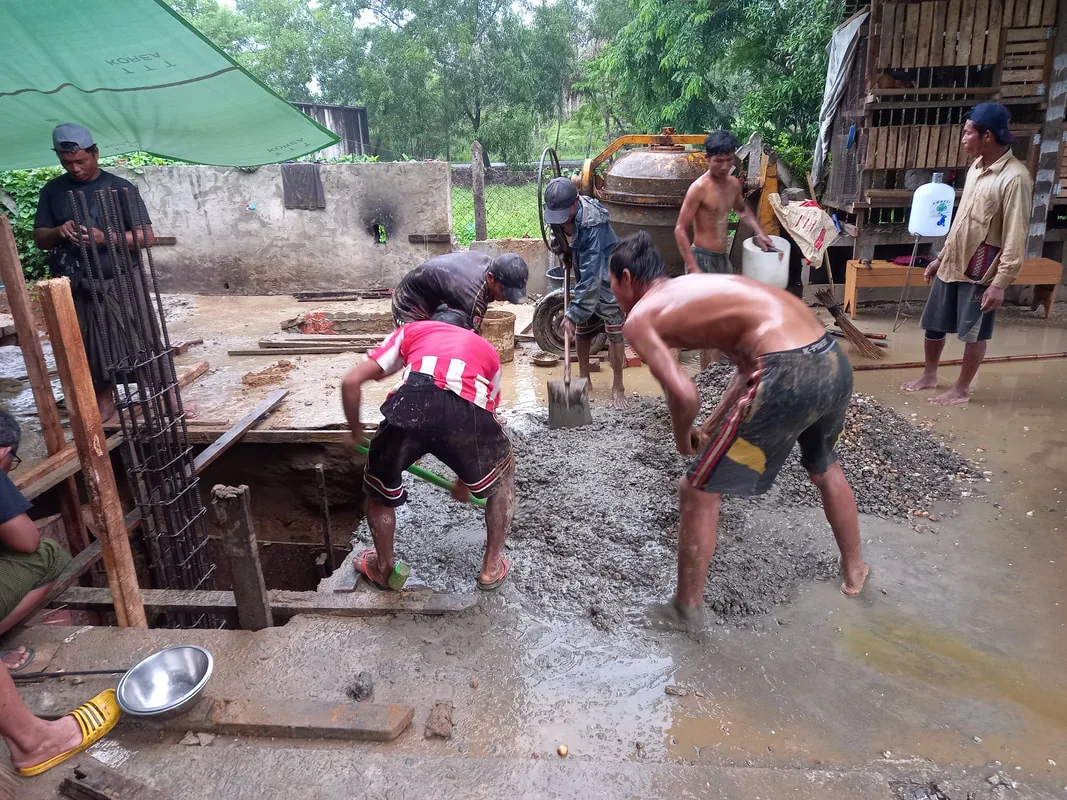 Workers mixing concrete at a building site