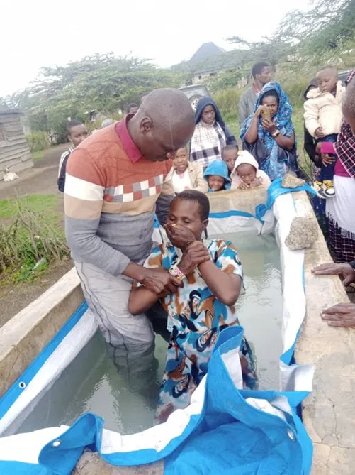 Men assisting a woman at a baptism