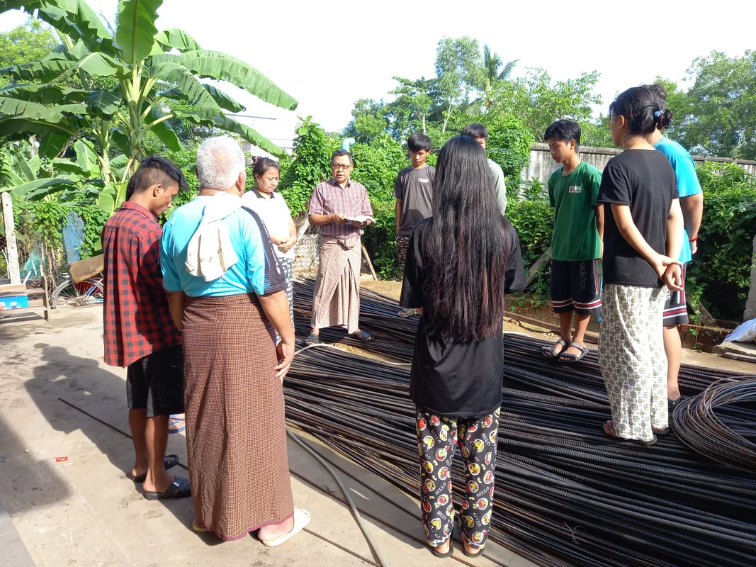 Group gathered beside steel reinforcing rods
