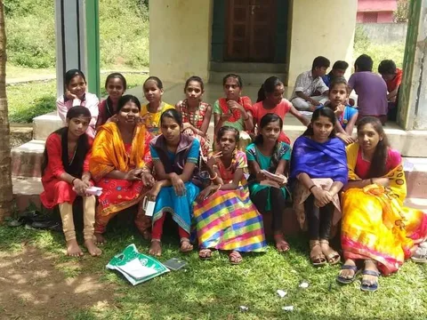 Children and adults posing together outside a building