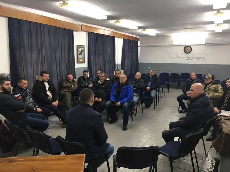 Men seated in a circle indoors