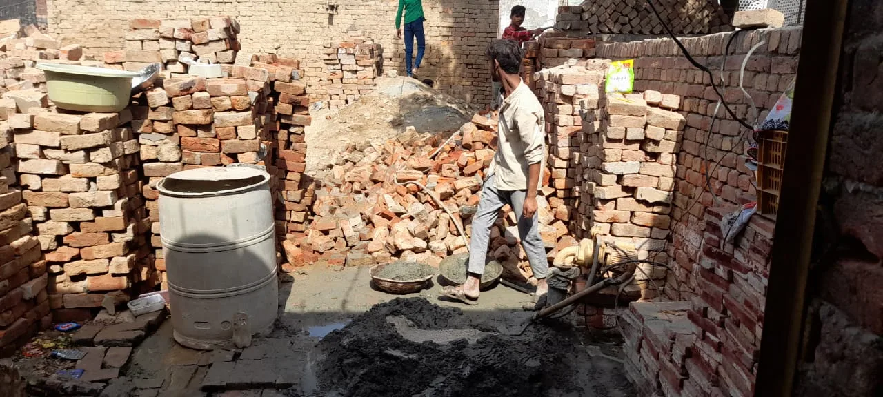 Worker clearing rubble between brick walls