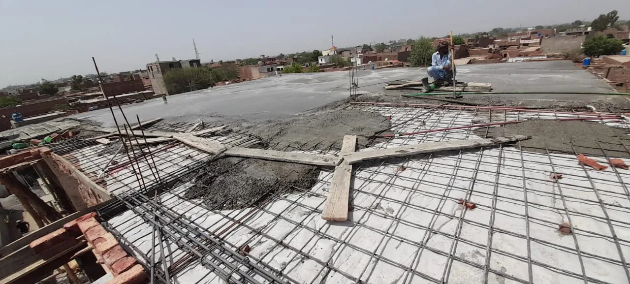 Concrete being laid over steel roof reinforcement