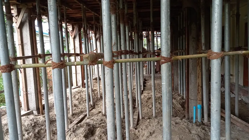 Temporary supports beneath a wooden floor form