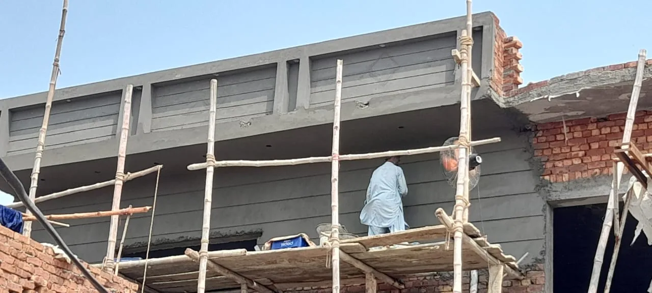 Plastered upper floor with workers on scaffolding
