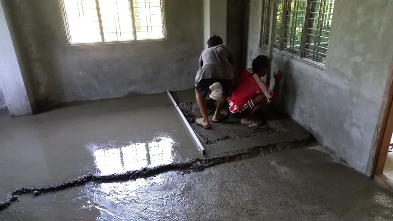 Workers leveling concrete flooring