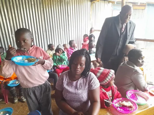 Children eating a meal inside a feeding center