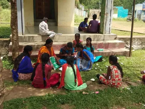Children gathered beside a porch for an outdoor lesson
