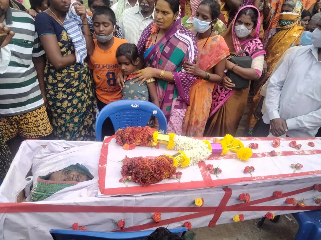 People gathered beside a decorated coffin