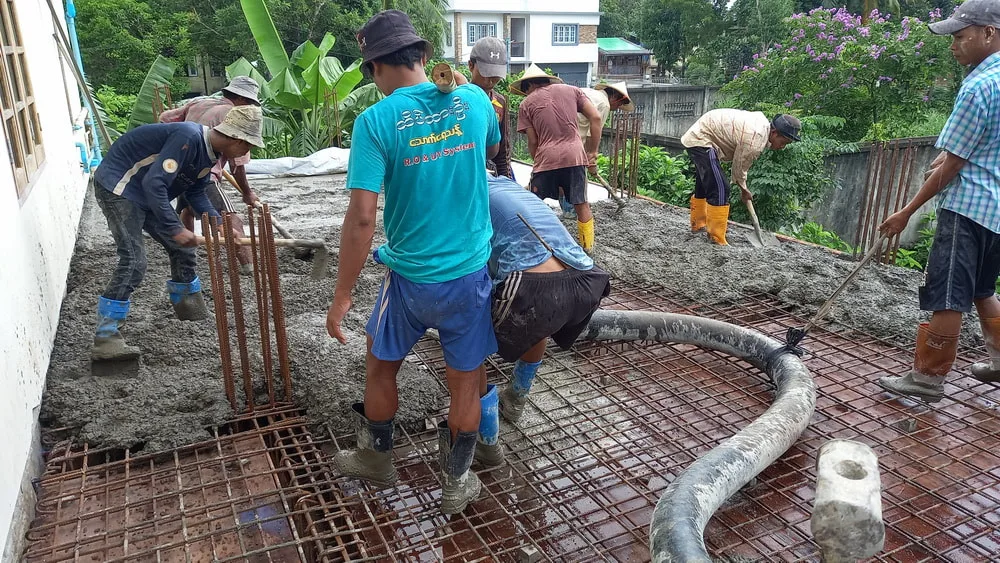 Workers spreading concrete at a building site