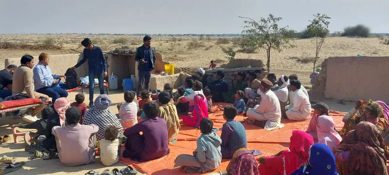 Speaker addressing a group seated outdoors