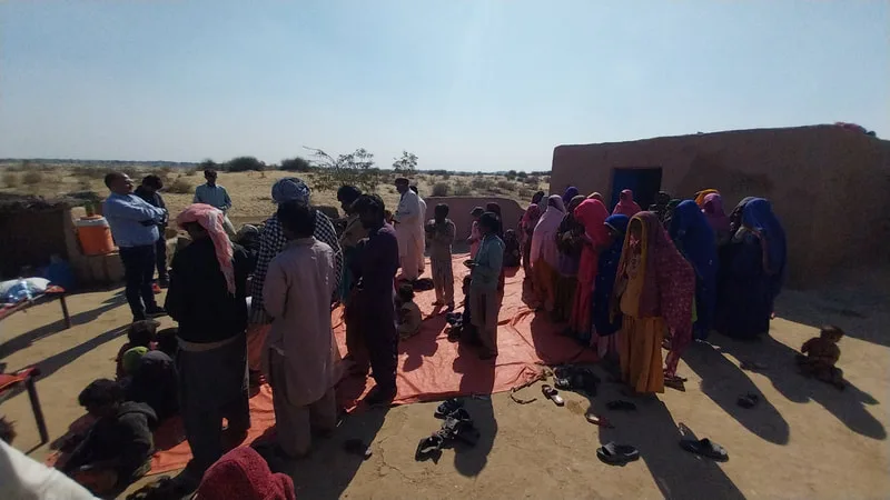 People gathered outdoors beside a brick building