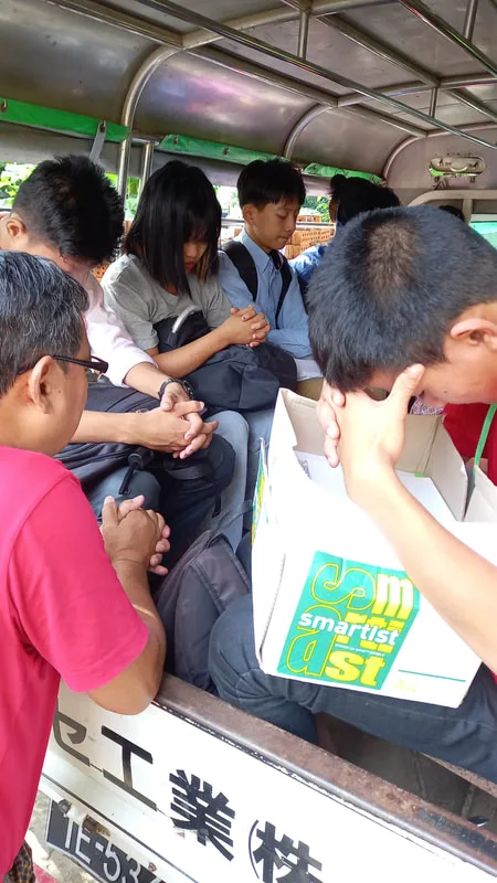 Children seated in a truck holding books