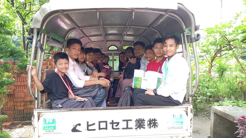 Children riding in the back of a small truck