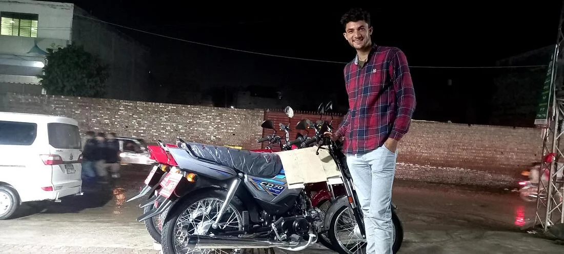 Man standing beside a motorcycle at night
