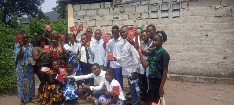 Adults and children gathered outside a brick building