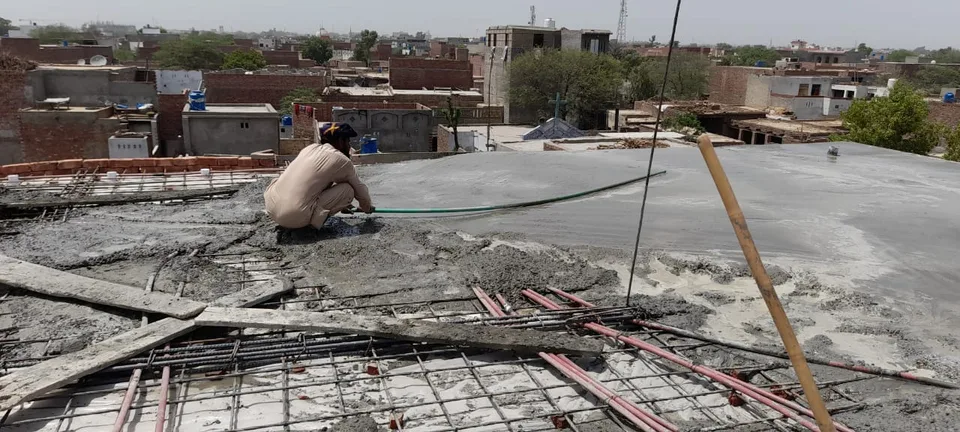 Worker smoothing freshly poured roof concrete