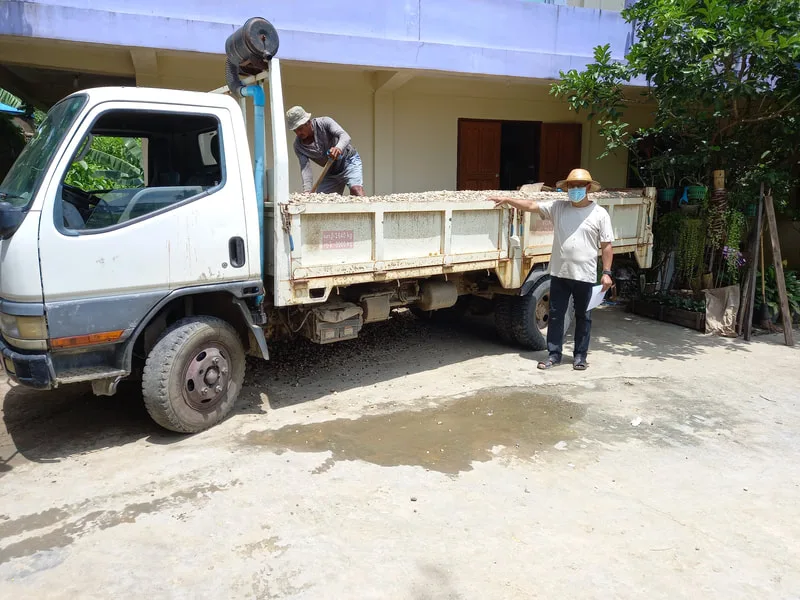 Workers unloading materials beside a house