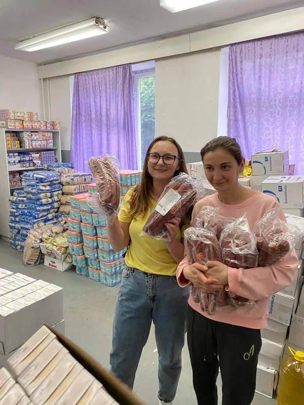 People holding supplies inside a storeroom