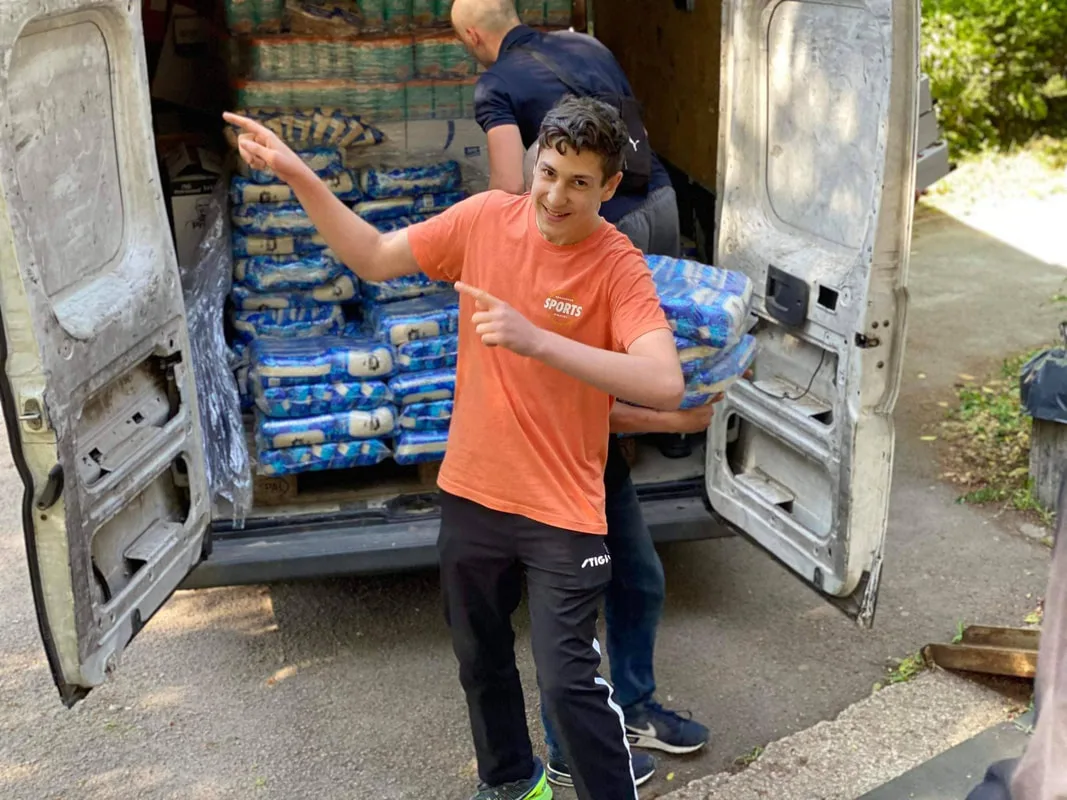 Person beside a van loaded with food supplies