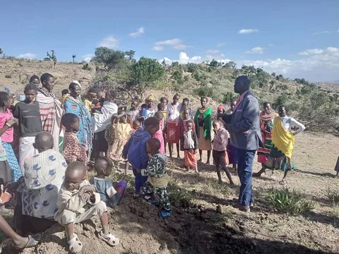 Speaker and group gathered outdoors