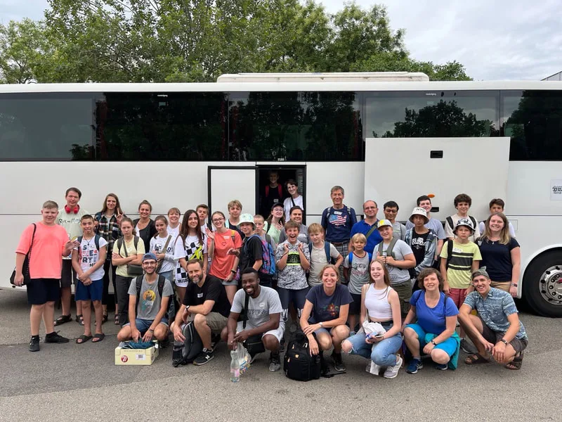 Large group beside a coach bus