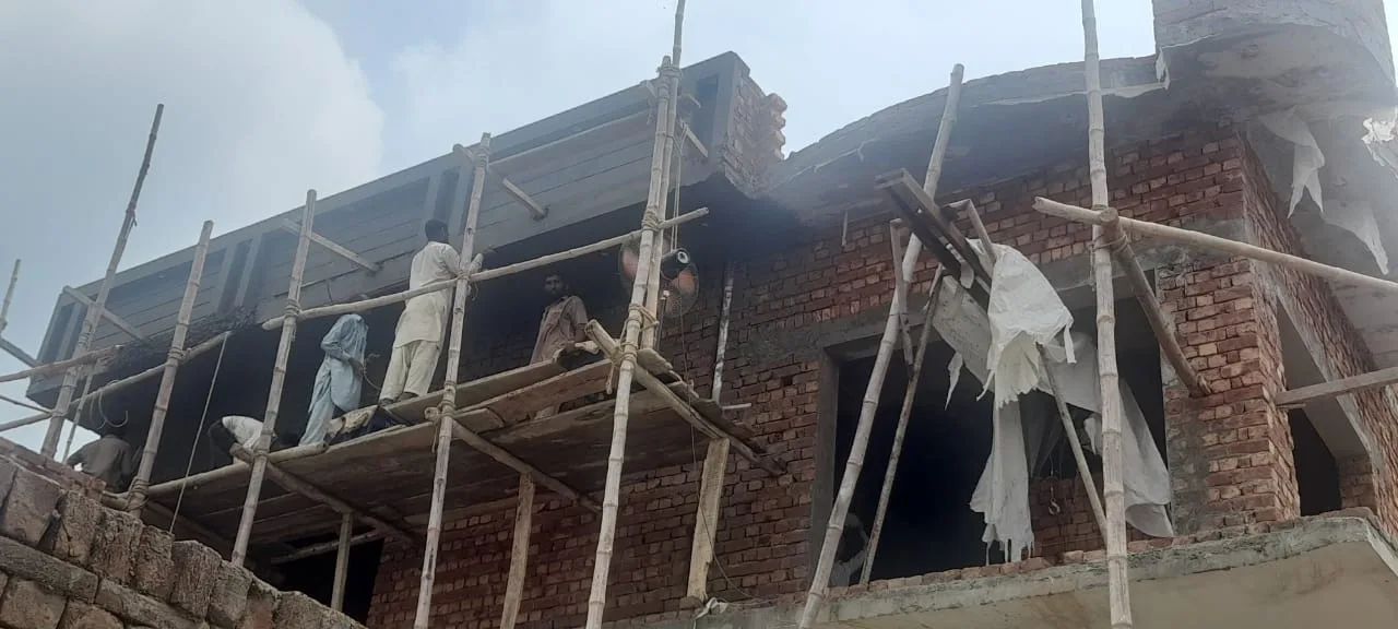 Scaffolding along the upper floor of a brick building