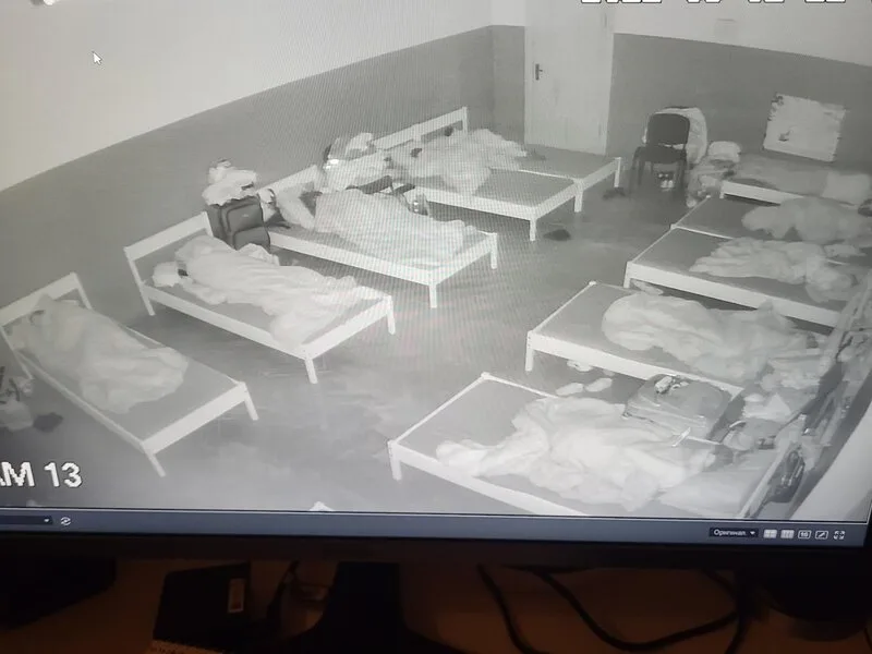 Night-vision view of a room with rows of beds