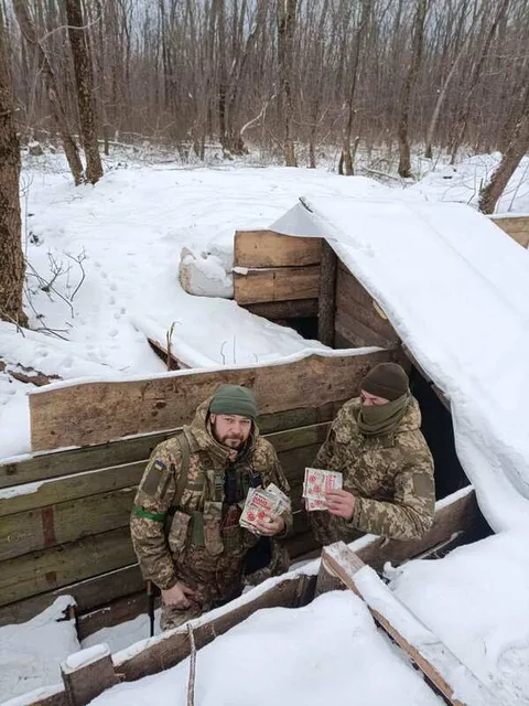Person sitting in a snow-covered trench
